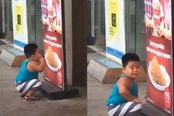 Thích ăn gà rán mà mẹ không cho, bé trai ngồi trước tấm biển ở cửa hàng và làm điều cực đáng yêu