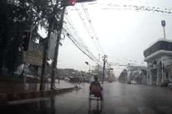Tài xế ôtô che dù cho người đi xe lăn đang đội mưa