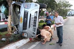 Ô tô 16 chỗ lao vào dải phân cách rồi lật nghiêng