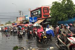 Người dân bì bõm lội nước đen ngòm sau cơn mưa như trút nước