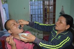 Mẹ mù lòa dò dẫm đút từng muỗng cơm cho con bại não