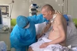 Bệnh nhân phi công người Anh ngồi dậy, đung đưa chân trên giường bệnh