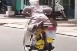Clip: Hốt hoảng cảnh gười phụ nữ lớn tuổi nằm cả lên yên xe máy đang chạy tốc độ cao trên đường