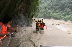 Dùng dây giải cứu gia đình mắc kẹt trong dòng nước lũ ở Trung Quốc