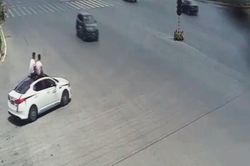 Trời nóng, 2 người đàn ông ngồi trên nóc ô tô 'chạy như bay' để hóng gió
