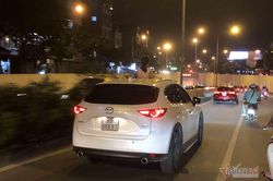 Bé gái đứng thò đầu qua cửa sổ trời, hóng gió Hà Nội