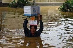 Người dân lội nước ngập sát cổ đi nhận hàng cứu trợ ở Quảng Bình