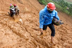 Hàng trăm người dân lội sình lầy mỗi ngày dưới chân núi lở