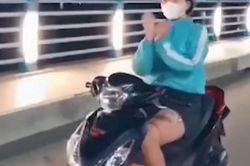 Chạy xe máy thả tay 'múa quạt', cô gái bị phạt 7,4 triệu đồng