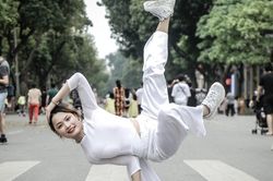 Cô gái mặc áo dài, tạo dáng hip hop trên phố đi bộ