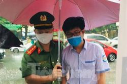 Hình ảnh đẹp chiến sĩ công an dầm mưa che chắn cho sĩ tử
