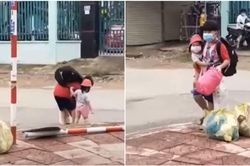 Ba mẹ đều là F0, bé trai một tay tất bật với túi đồ, một tay bế em nhỏ vào khu điều trị