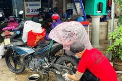 Một đoàn viên sửa xe miễn phí cho người dân về từ miền Nam