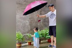Clip: Bố che mưa cho gái nhỏ tưới cây khiến dân mạng 'lịm tim'