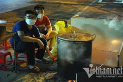 Cảnh bếp lửa hồng, tết đoàn viên ngồi trông nồi bánh chưng trên phố ở Hà Nội