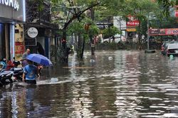 Người Hà Nội bì bõm lội trên các phố sau cơn mưa tháng Năm