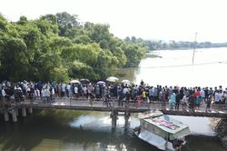 Người dân đứng kín bờ sông xem đội cứu hộ tìm kiếm cô gái mất tích