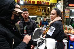 Dán mã QR lên người vì quá đông khách đi chợ Tết muốn chuyển khoản