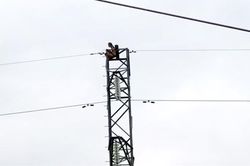 Cô gái trẻ không mặc quần áo ngồi vắt vẻo trên trụ điện cao thế