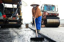 Công nhân đội nắng trải thảm nhựa trên công trường cầu Vĩnh Tuy giai đoạn 2