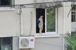 Hãi hùng cảnh cậu bé đứng bấp bênh bên mép cửa sổ chung cư
