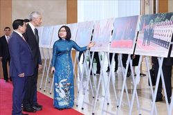 Thủ tướng Phạm Minh Chính và Thủ tướng Lý Hiển Long xem trưng bày ảnh về hợp tác Việt Nam - Singapore