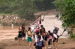 Hiệu trưởng cõng học sinh lội bùn đến trường