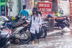 Người dân bì bõm về nhà trên những con phố ngập nước ở Hà Nội