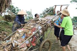 Cô giáo nghẹn ngào nhìn sách vở của học sinh ngập trong bùn đất