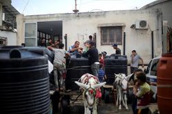 Người đàn ông và chú lừa kéo xe phân phát nước ở Dải Gaza