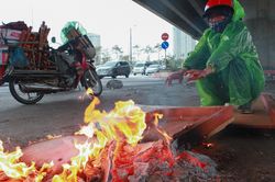 Người lao động đốt lửa chống chọi với rét đậm, đường phố Hà Nội vắng lạ thường
