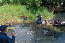 Cán bộ và người dân dầm mình dưới nước đen giúp sông thoát cảnh tù đọng