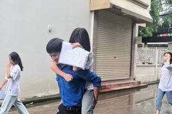 Nam đoàn viên cõng thí sinh nữ bị băng bó chân vào phòng thi