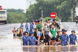 Cảnh sát biển ngâm mình dìu dân vượt qua điểm ngập sâu gần 1m ở Hà Nội