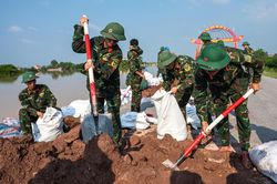 Người dân, bộ đội đắp đê ngăn nước lũ sông Cầu
