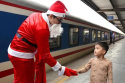 Hành khách đi tàu thích thú khi được ông già Noel tặng quà