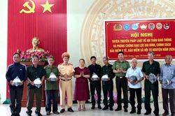 Công an xã Đắk Song tuyên truyền pháp luật và tặng mũ bảo hiểm cho người dân