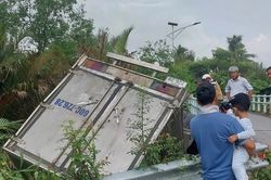 Xe tải tông lan can cầu rơi xuống kênh, tài xế mắc kẹt trong cabin