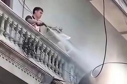 Người đàn ông liên tục xịt nước vào thợ đang tháo dỡ công trình