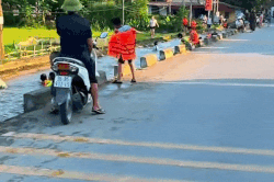 Hàng chục người tắm mát dưới con mương nằm sát đường lớn