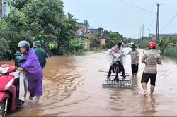 Lực lượng chức năng hỗ trợ người d&acirc;n qua điểm ngập tr&ecirc;n Quốc lộ 279
