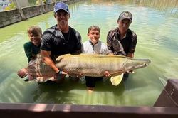 B&eacute; trai c&acirc;u được con c&aacute; khổng lồ nặng 130kg trong hồ