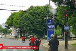 Nh&oacute;m học sinh đi xe điện vượt đ&egrave;n đỏ, kh&ocirc;ng đội mũ