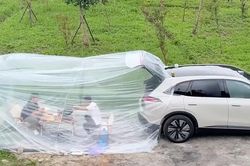 Hai người đàn ông dựng 'phòng điều hòa' sau ô tô để nấu ăn dưới trời nắng nóng