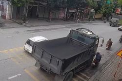 Xe ben vượt phải ở giây cuối đèn xanh, ép xe máy vào lề rồi cán qua