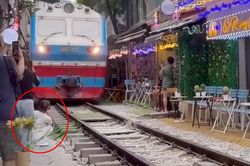 Thông tin bất ngờ vụ cô gái ngồi sát đường tàu ở Hà Nội bị tàu hỏa hất văng điện thoại