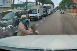 Bất ngờ cắt ngang dòng xe chờ đèn đỏ, người phụ nữ đi xe máy chở trẻ nhỏ bị tông trúng