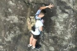 Mắc kẹt trên vách đá cao 80m không dây bảo hộ, người đàn ông có hành động gây tranh cãi