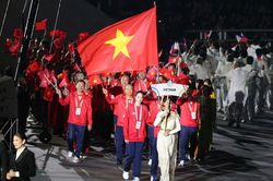 Hai vận động viên Thanh Thúy, Quang Kiệt cầm cờ Việt Nam tại lễ khai mạc ASIAD 2026