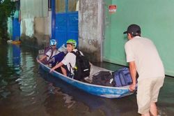 Mưa tạnh hơn một ngày, hẻm ở TPHCM vẫn ngập sâu, dân dùng thuyền đưa con đi học
